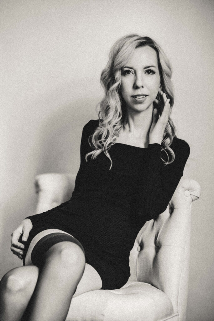 Elegant black and white editorial portrait with dramatic lighting and natural expression