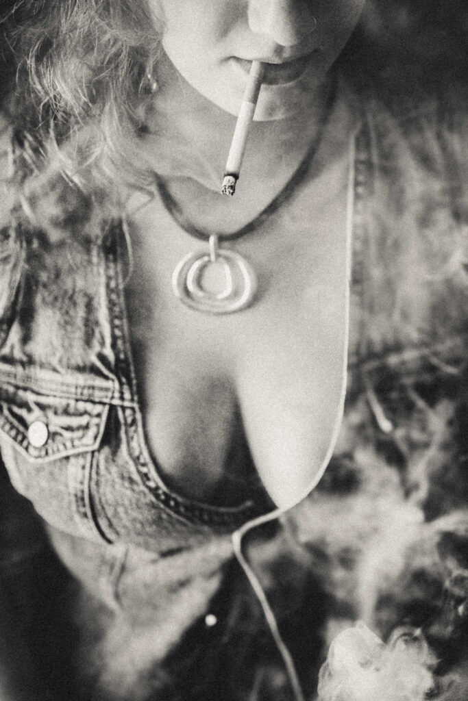 Luxury boudoir portrait inspired by 1970s fashion photography with smoky studio lighting, the cigarette photo is back.