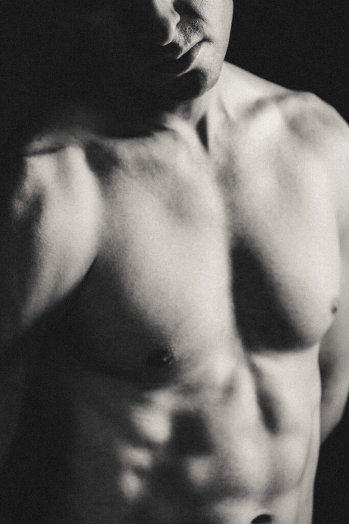 Black and white male boudoir portrait highlighting confidence and natural expression.